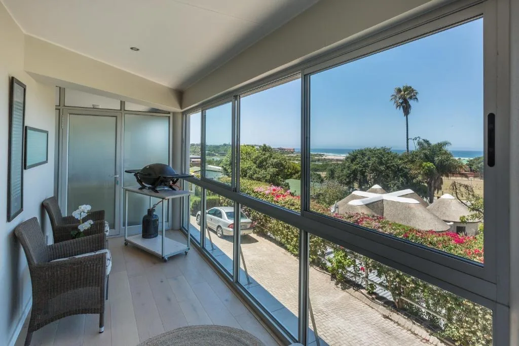 Panoramic ocean and coastal landscape visible through expansive deck windows