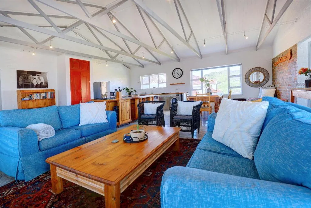 Spacious open-plan lounge with blue sofas and wooden coffee table