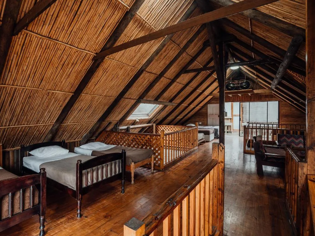 Rustic wooden loft bedroom with multiple beds and exposed beam architecture
