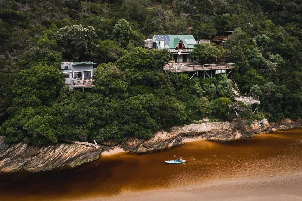 Aerial view of riverfront properties nestled in lush forest along Kaaimans River