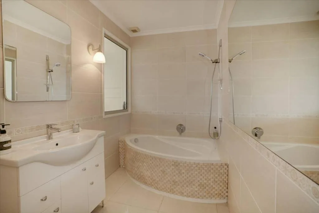 Modern bathroom with curved bathtub, shower enclosure, and vanity sink