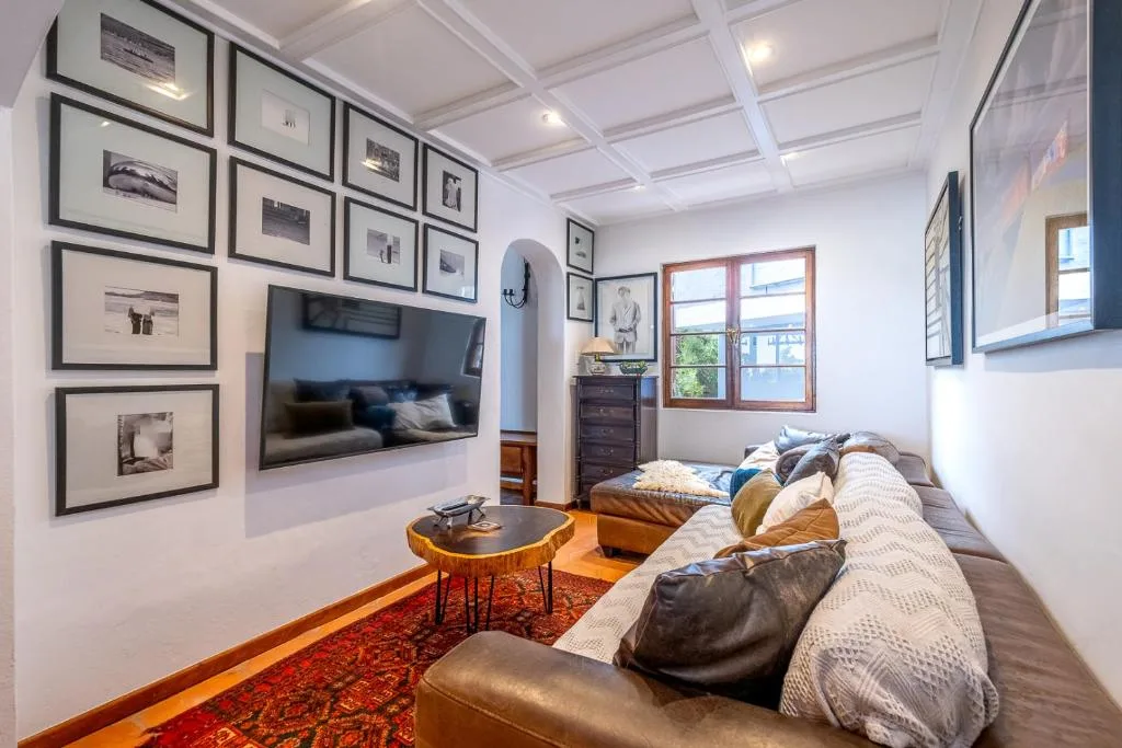 Bright lounge with sofa, wall-mounted TV, framed artwork, and ocean view windows