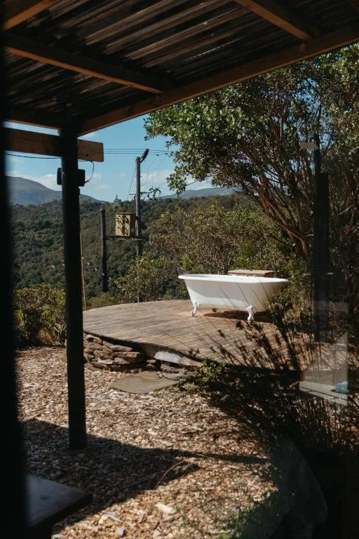 Outdoor bathtub on wooden deck with mountain views and pergola shelter