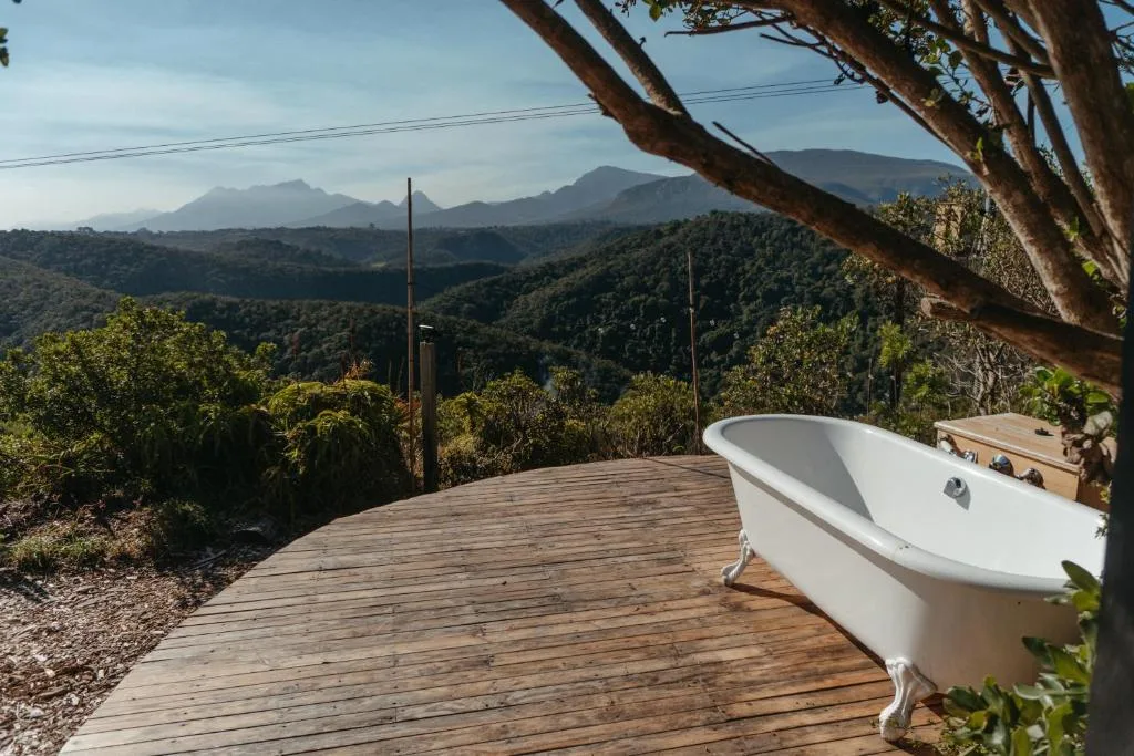 Wooden deck with freestanding bathtub overlooking mountain landscape views
