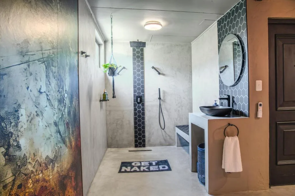 Modern bathroom with walk-in shower, black hexagonal tiles, and floating vanity