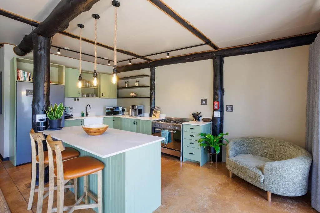 Modern kitchen with green cabinetry, island counter, and pendant lighting