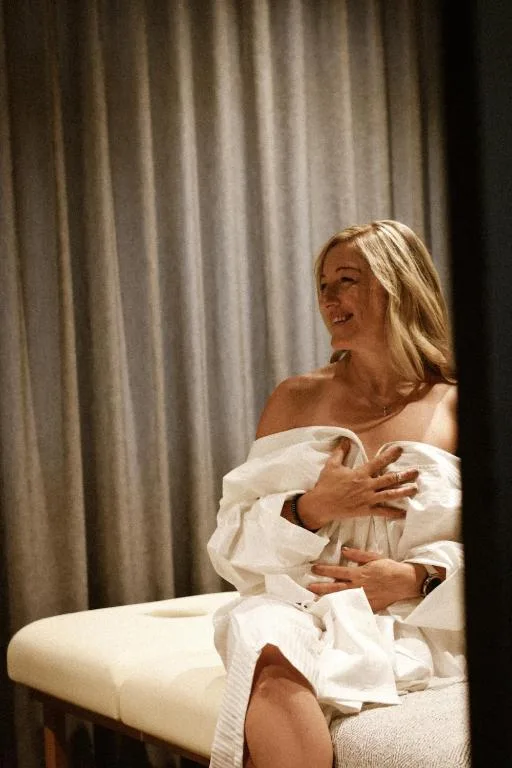 Woman relaxing on cream sofa against striped curtain backdrop