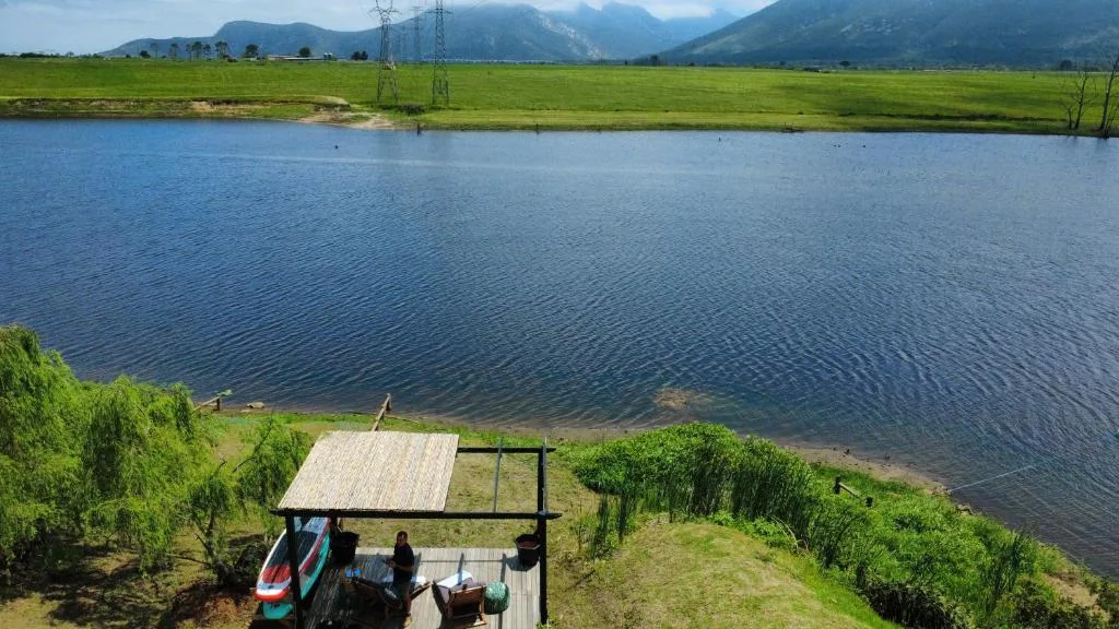 Scenic lagoon and mountain vista from waterfront deck with kayaks