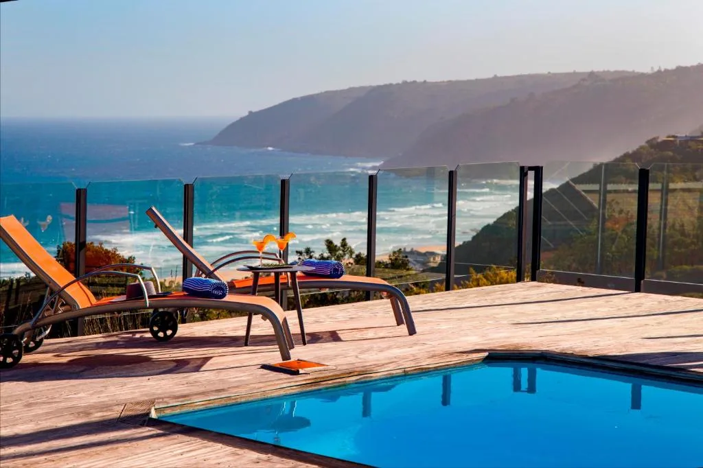 Swimming pool with ocean and coastal cliffs view from deck