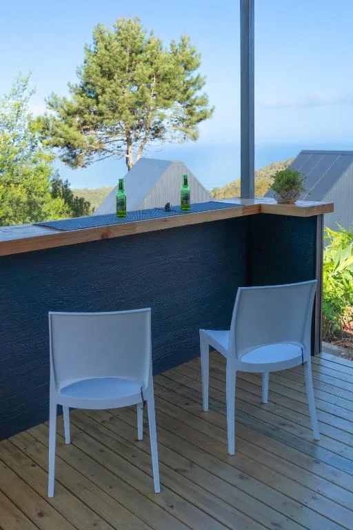 Outdoor deck with white chairs and bar counter overlooking mountains