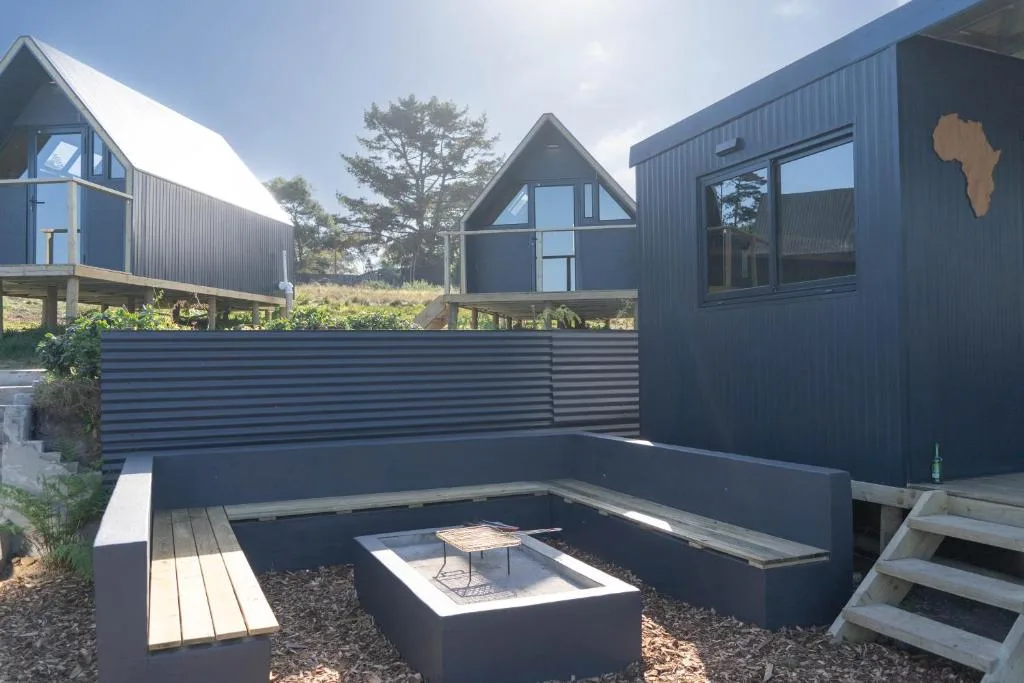 Modern sunken seating area with fire pit surrounded by contemporary chalets