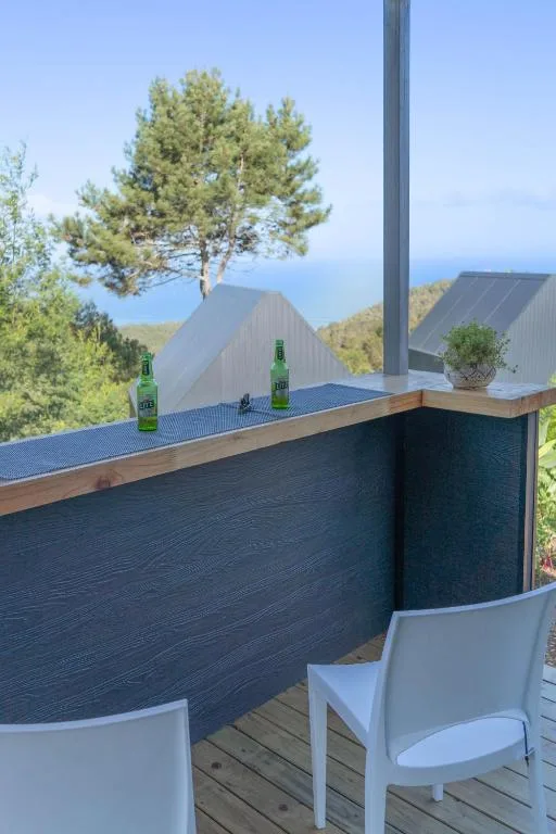 Outdoor deck with white chairs and bar counter overlooking mountains