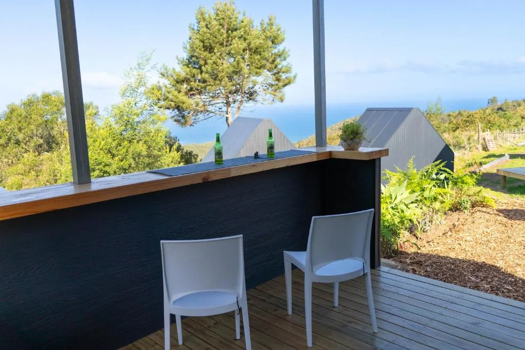 Outdoor deck with seating overlooking ocean and mountains