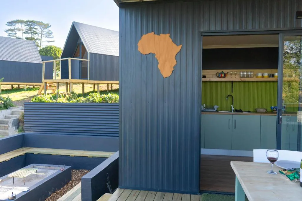 Modern glamping pods with corrugated metal exterior and Africa map decoration