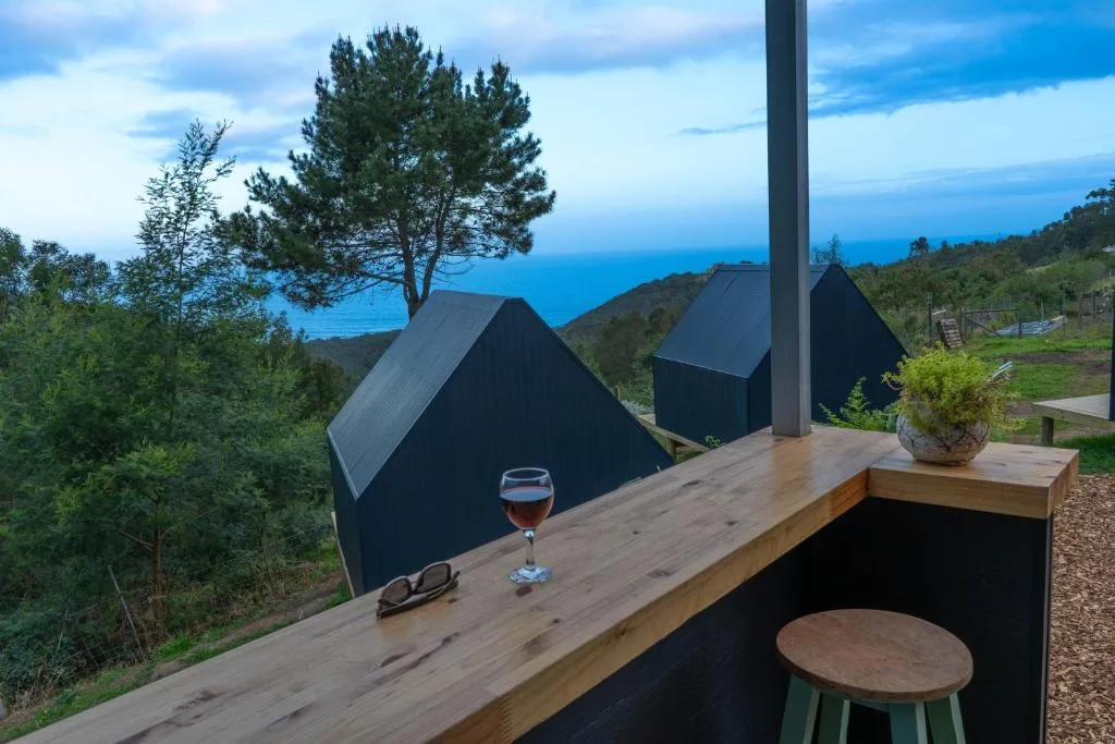 Ocean vista from wooden deck with wine glass and seating area