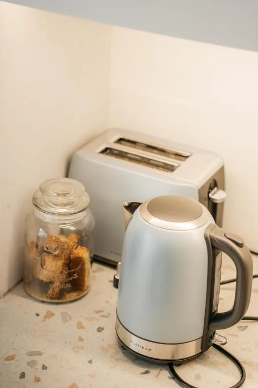 Kitchen countertop with white kettle, toaster, and cookie jar