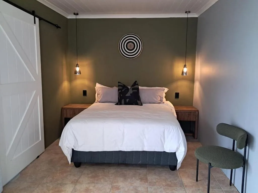 Modern bedroom with queen bed, pendant lighting, and olive green walls