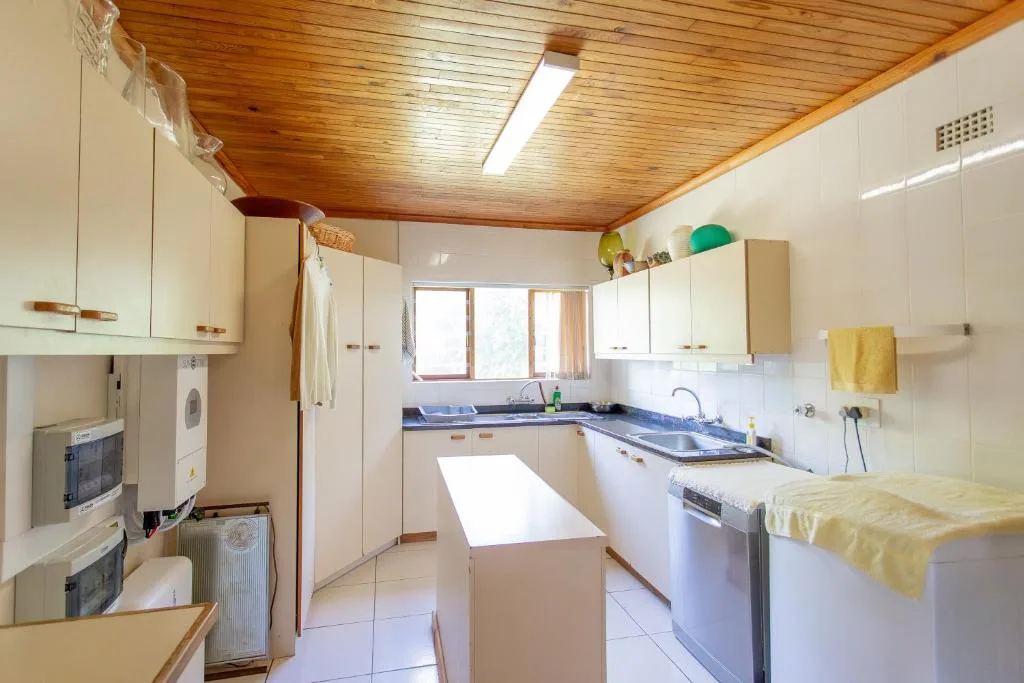 Spacious kitchen with cream cabinetry, blue countertops, and wooden ceiling