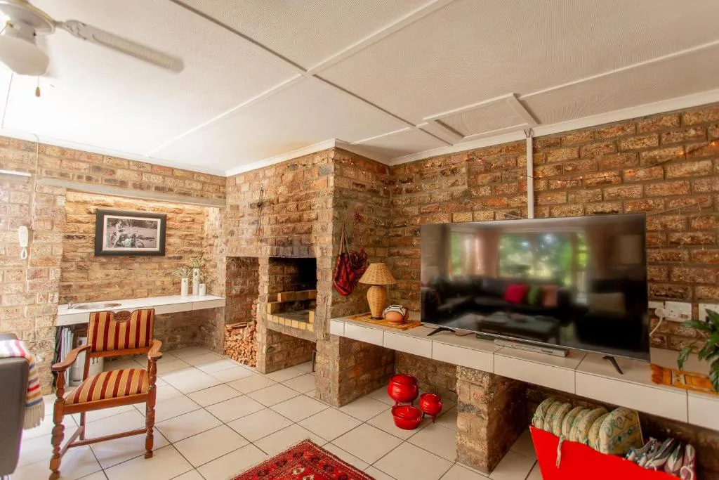 Spacious lounge with fireplace, TV, and exposed brick walls