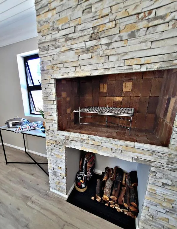 Stone fireplace with built-in braai grill and storage space below