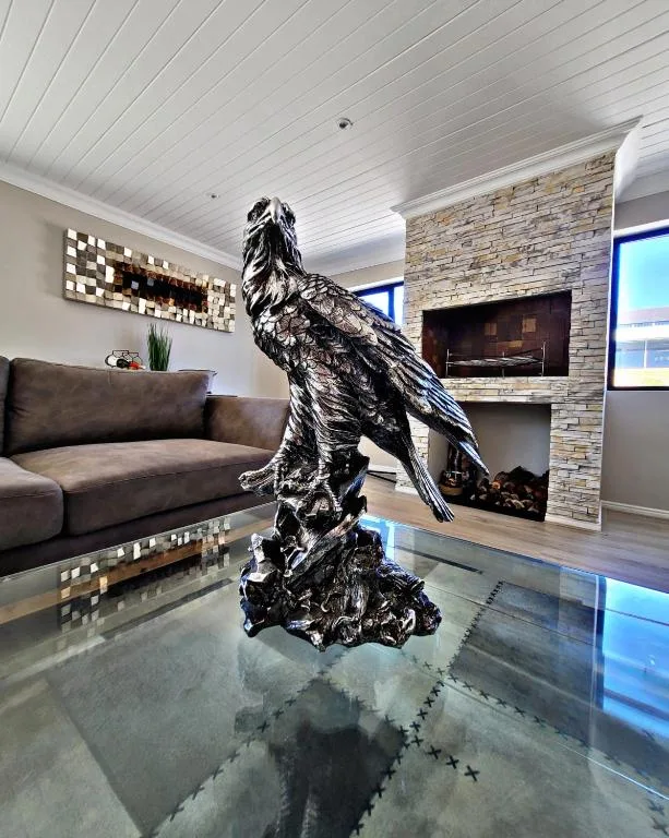 Modern lounge with sofa, fireplace, and striking black eagle sculpture