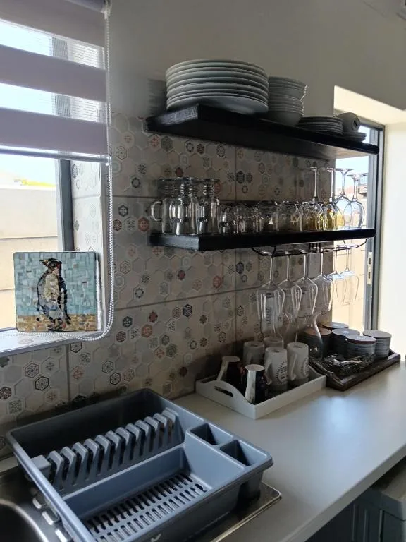 Modern kitchen shelving with organized plates, glasses, and dishware storage