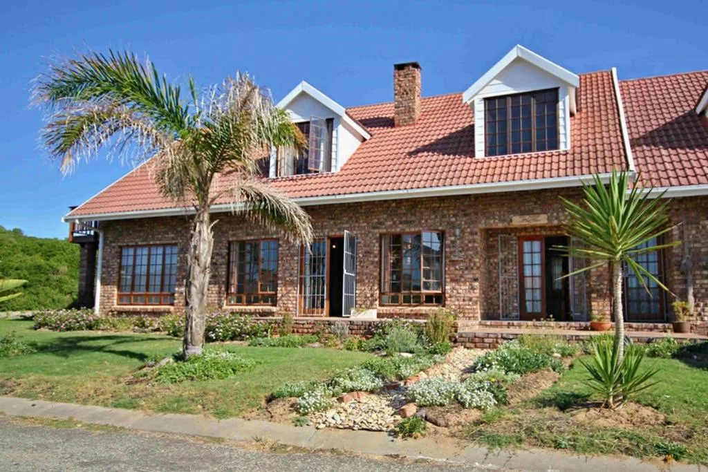 Brick and stone house with terracotta roof and palm trees