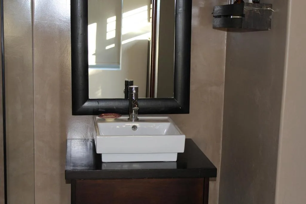 Modern bathroom vanity with white sink and black framed mirror