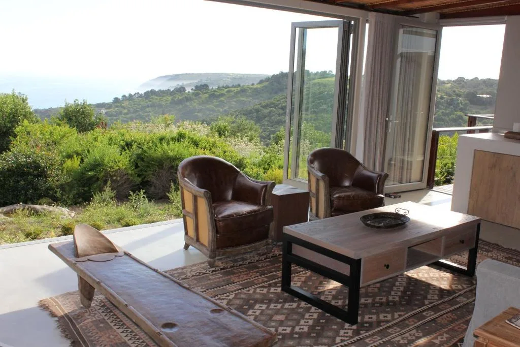 Outdoor seating area with chairs overlooking lush mountain landscape