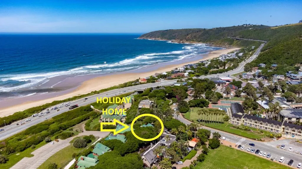 Aerial view of pristine beach, ocean, and coastal village with property highlighted
