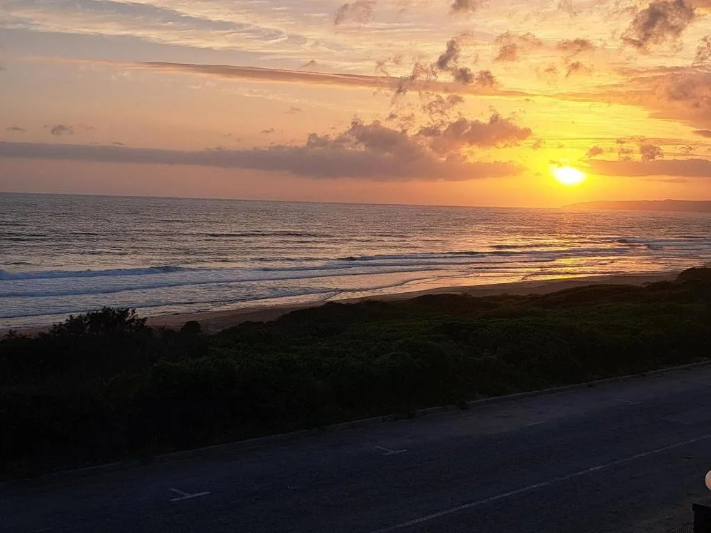 Golden sunset over ocean with waves and beach from property vantage