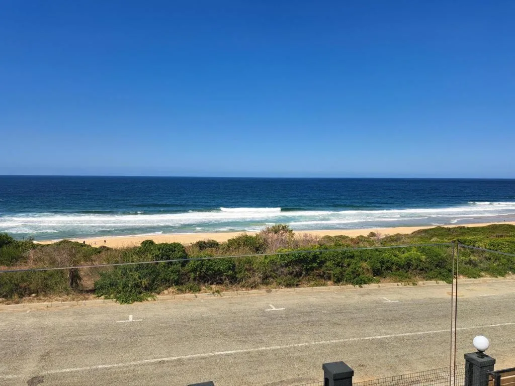 Panoramic ocean and beach vista with rolling waves and golden sand