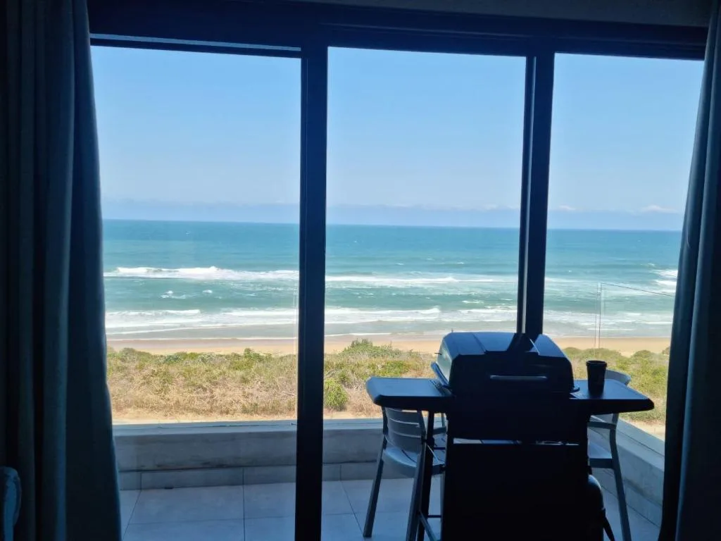 Oceanfront vista with turquoise waves and golden beach from property windows