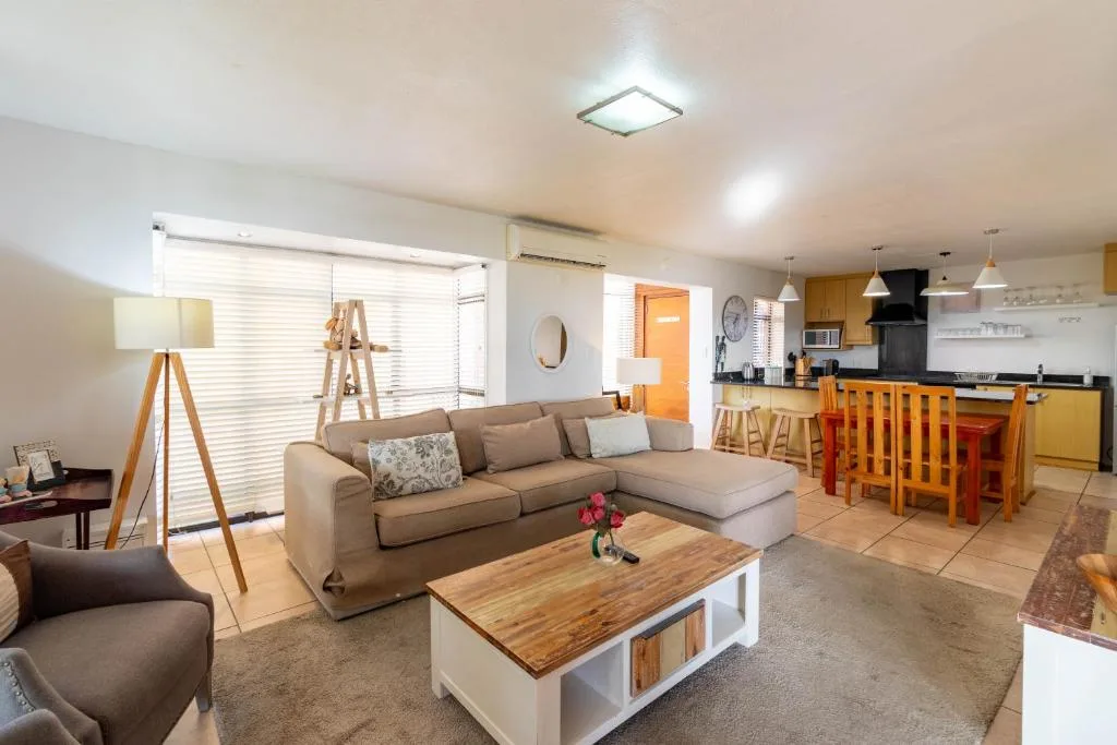 Open-plan lounge with beige sectional sofa and wooden coffee table