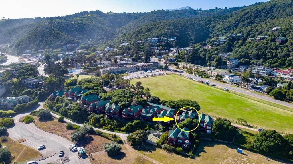 Aerial view of property nestled in lush green valley with river and mountains