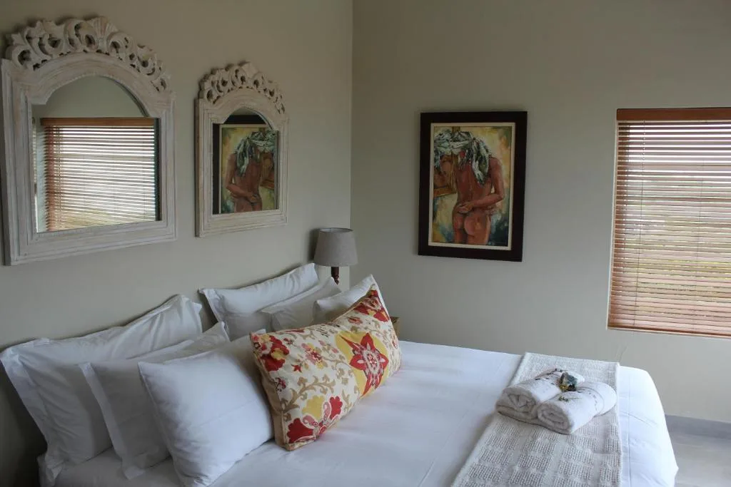 Bright bedroom with white pillows, colorful decorative cushion, ornate mirror frames
