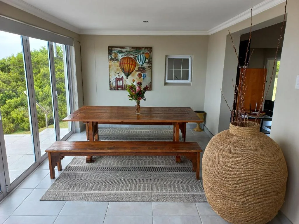 Wooden dining table and bench with garden views through sliding doors